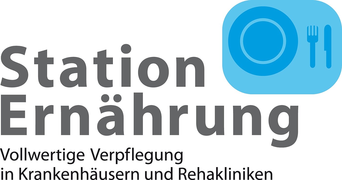 Logo Station Ernährung Logo von 'Station Ernährung' mit blauer Teller- und Besteckgrafik. Text in grauer Schrift: 'Station Ernährung'.